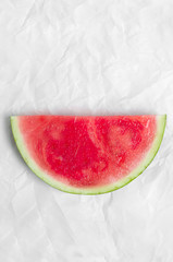 Fototapeta na wymiar Sliced ​​watermelon on a white parchment