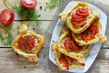 Pies portion with red fish (salmon and puff pastry) and tomatoes