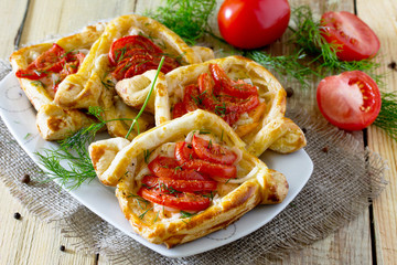 Cakes with red fish (salmon) and tomatoes on a table in a rustic