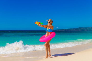 Fototapeta na wymiar Young beautiful girl in blue bikini having fun on a tropical bea