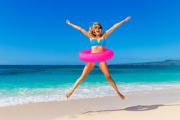 Fototapeta na wymiar Young beautiful girl in blue bikini having fun on a tropical bea