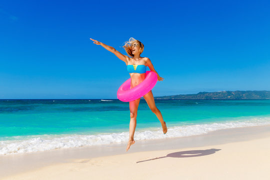 Young beautiful girl in blue bikini having fun on a tropical bea