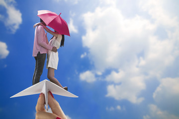 Couple ride paper plane on blur sky background