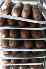 Fresh baguettes in tray stacked on shelf