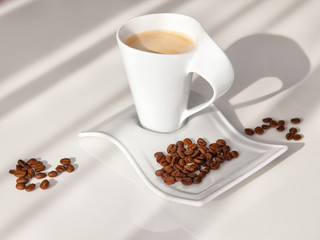 white mug of coffee with grains on a white background