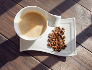 Küchenrückwand glas motiv Cafe weiße Tasse Kaffee mit Körnern auf einem hölzernen Hintergrund