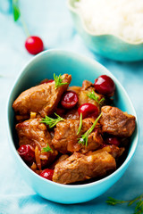 stewed pork with cherry in a blue bowl