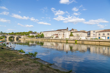 Fototapeta na wymiar Cognac, France. Quay of the Charente River. From left to right: the bridge, the castle of Valois (X - XV centuries) now house Otard Cognac, the city Gate of St. James with towers (1499)