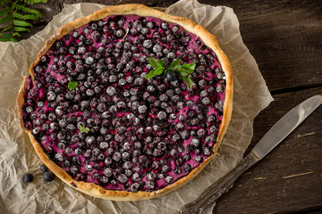 Homemade pie with bilberry  on dark wooden table