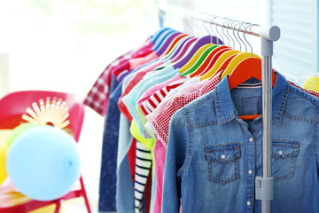 Children clothes hanging on hangers in the shop