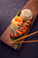 Teriyaki salmon with quinoa on a wooden platte