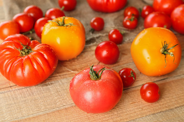 Rustic composition of tomatoes and sackcloth on wooden background