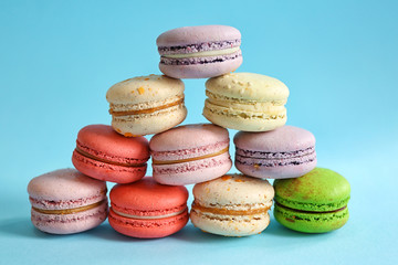 Tasty colorful macaroons on light blue background