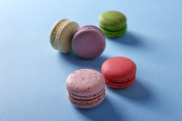 Tasty colorful macaroons on light blue background