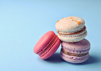 Tasty colorful macaroons on light blue background