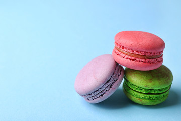 Tasty colorful macaroons on light blue background