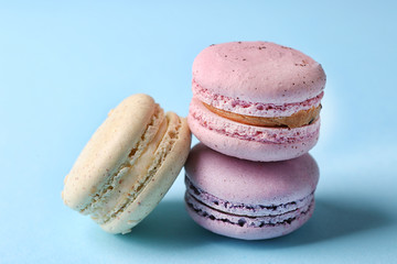 Tasty colorful macaroons on light blue background