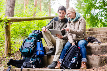 Hikers determinating their position by GPS on tablet PC