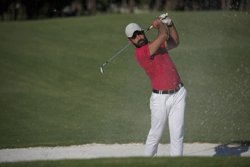 golfer hitting a sand bunker shot