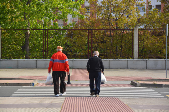 dos ancianos cruzando un paso de peaones