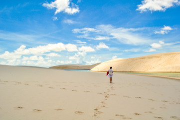 Girl walking the dunes in Lencois Maranhenses National Park, Bra