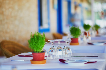 Wine glasses and green plant on the table of restaurant in Portugal