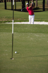 golfer hitting a sand bunker shot