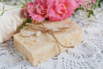 Natural handmade soap, aromatic oil and flowers on white wooden