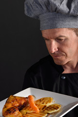 chef preparing a chicken dish with garnish