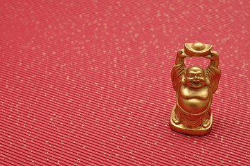 Fototapeta na wymiar Figurine of laughing and cheerful golden Buddha