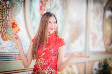 The chinese woman dress traditional cheongsam and hold red envel