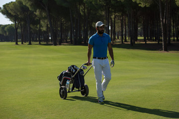 golf player walking with wheel bag