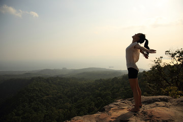 young freedom woman open arms on mountain peak