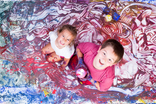 Happy girl and boy painting with their hands