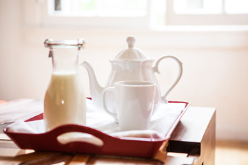 Fototapeta na wymiar Breakfast tray on a table / Breakfast tray on a table with milk bottle and teapot
