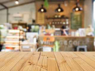 Wooden table with blurred coffee shop background