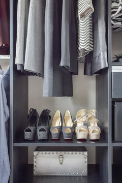 row of women's shoes on black wooden shelf