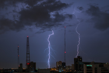 Lightning storm over city in purple light
