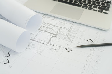 black pencil and computer laptop on architectural drawing paper for construction