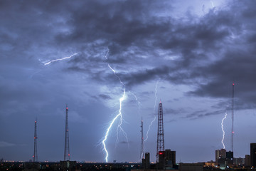 Lightning storm over city in purple light
