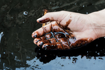 crude oil in hand due to crude oil leak.crude oil low price concept.