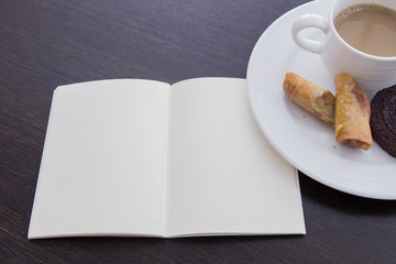 a cup of coffee and a book on the wood table