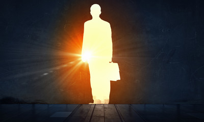 Silhouette of businessman in wall . Mixed media