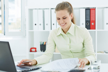 Beautiful young smiling secretary make notes sitting at office. Business, exchange market, job...