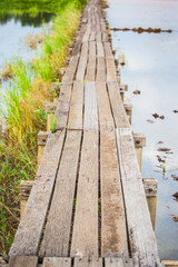 Fototapeta premium Old wooden bridge through the field .