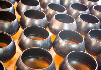 Many metal alms bowl for people make a merit