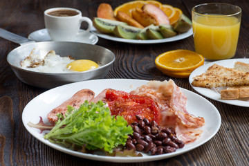 Full English breakfast with sausage, baked tomato, beans and toa
