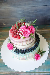 Obraz na płótnie Canvas wedding color drip cake with roses, blueberries and raspberries