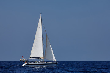 Obraz na płótnie Canvas The white sails of yachts on the background of sea and sky