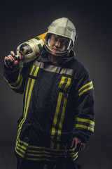 Fototapeta premium Firefighter in safety costume holding oxygen tank.